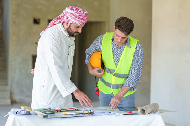 Arabic business teammates working together in office, construction engineer equipment on desk of Arab businessman.